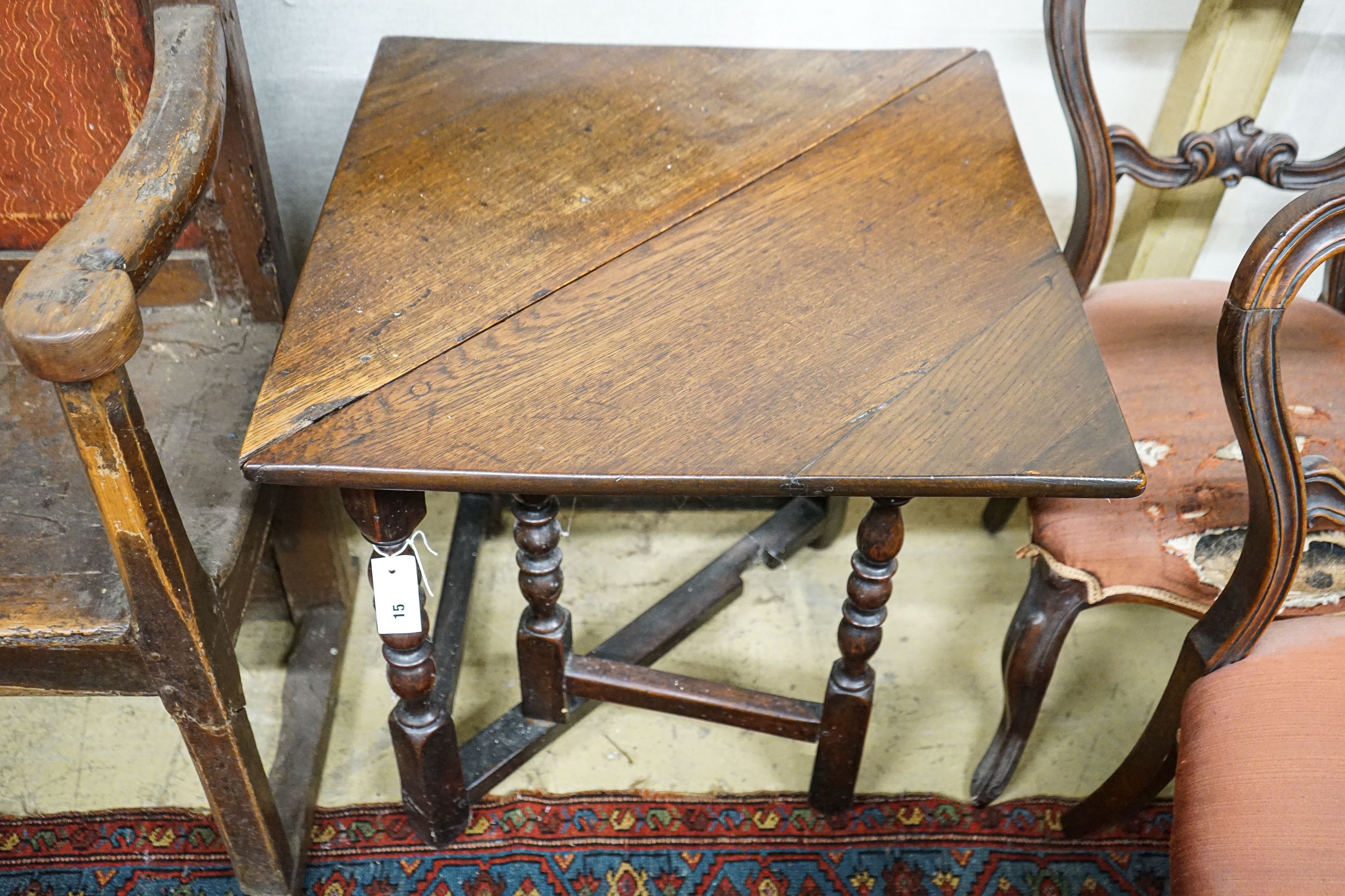 An early 18th century oak drop leaf table, with triangular flap and turned gateleg action underframe, width 62cm, depth 62cm, height 68cm
